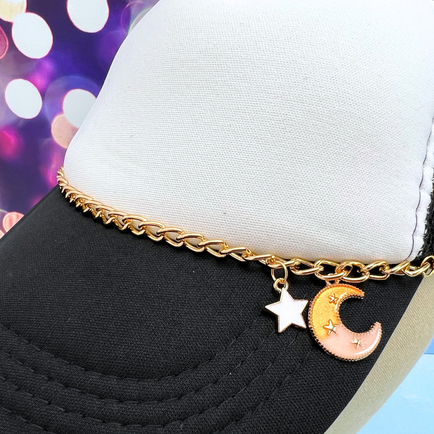 Gold chain bracelet with star and moon charms on a black and white background