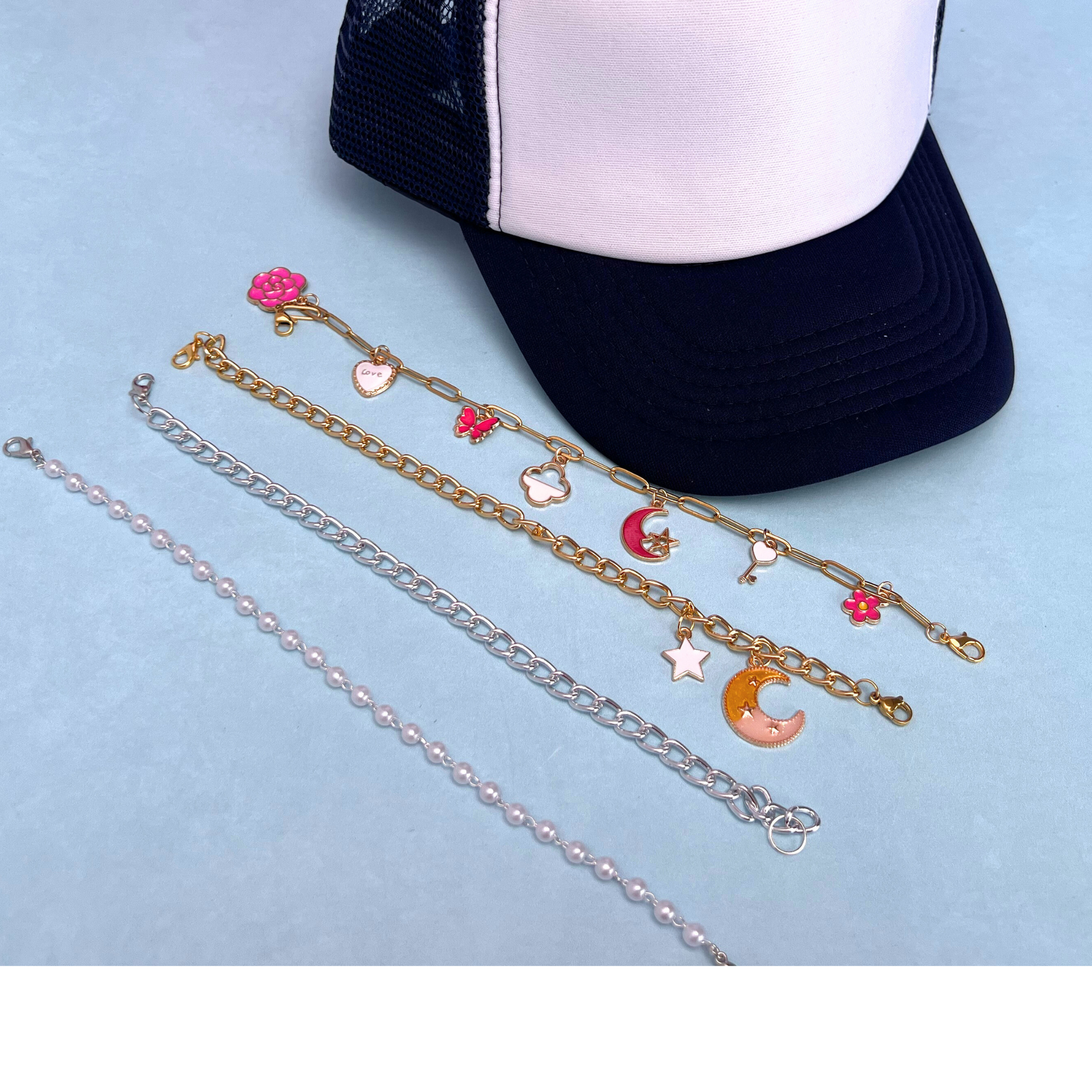 Three necklaces with charms on a light blue background