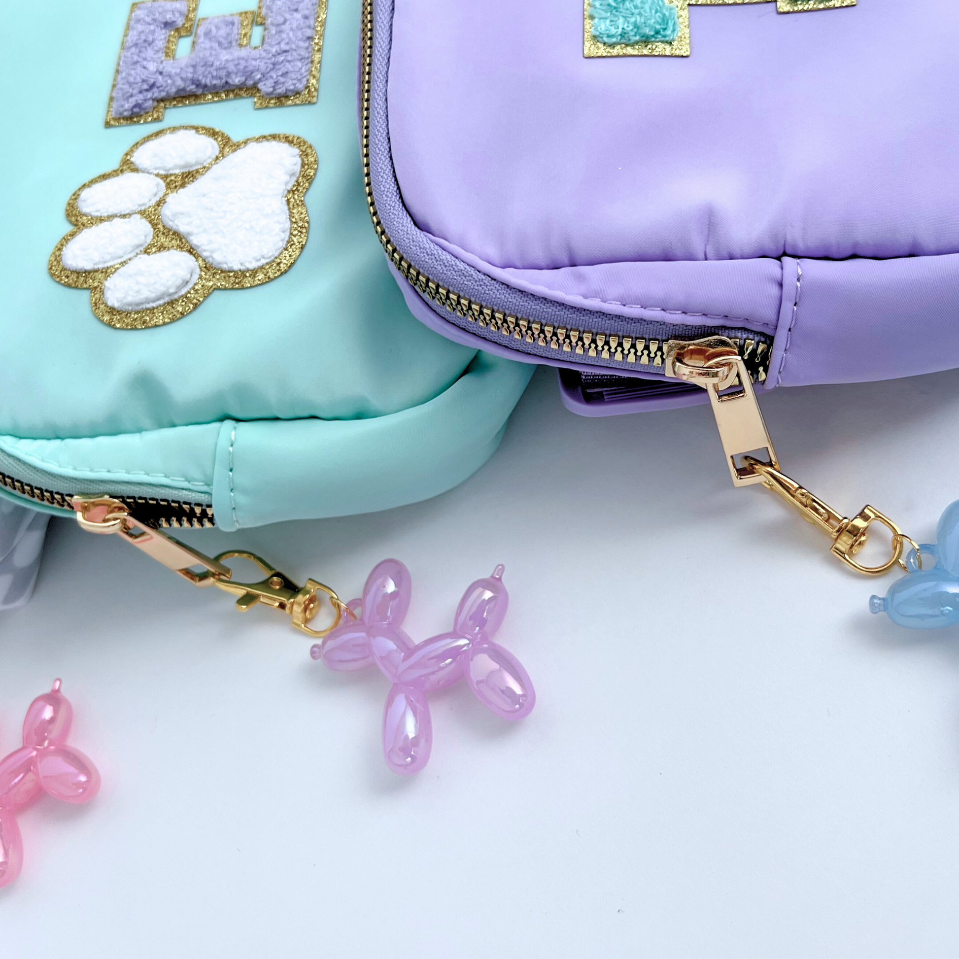 Two colorful pouches with gold zippers and decorative elements on a light background