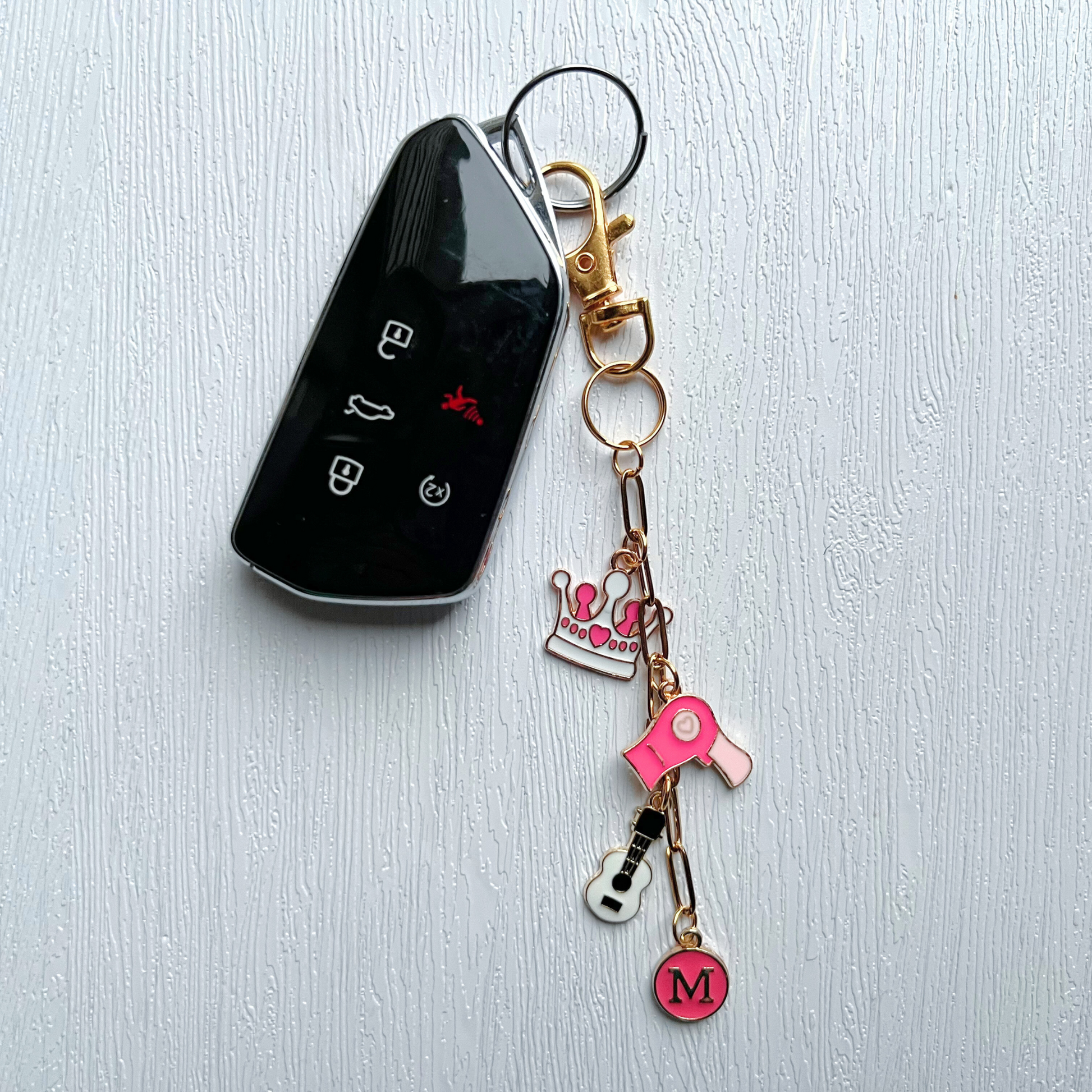 Keychain with charms attached to a car key on a light gray background