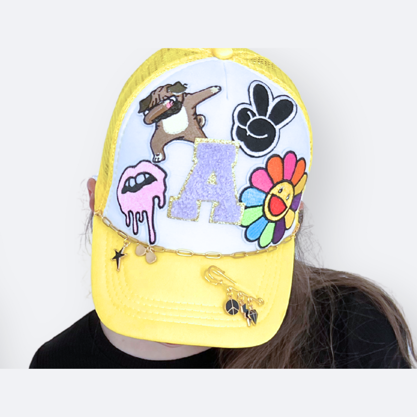 Yellow cap with colorful designs and text on a white background