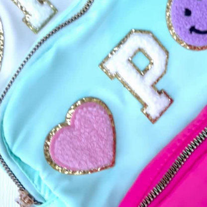 Colorful pouch with letter 'P' and heart design on a light blue background