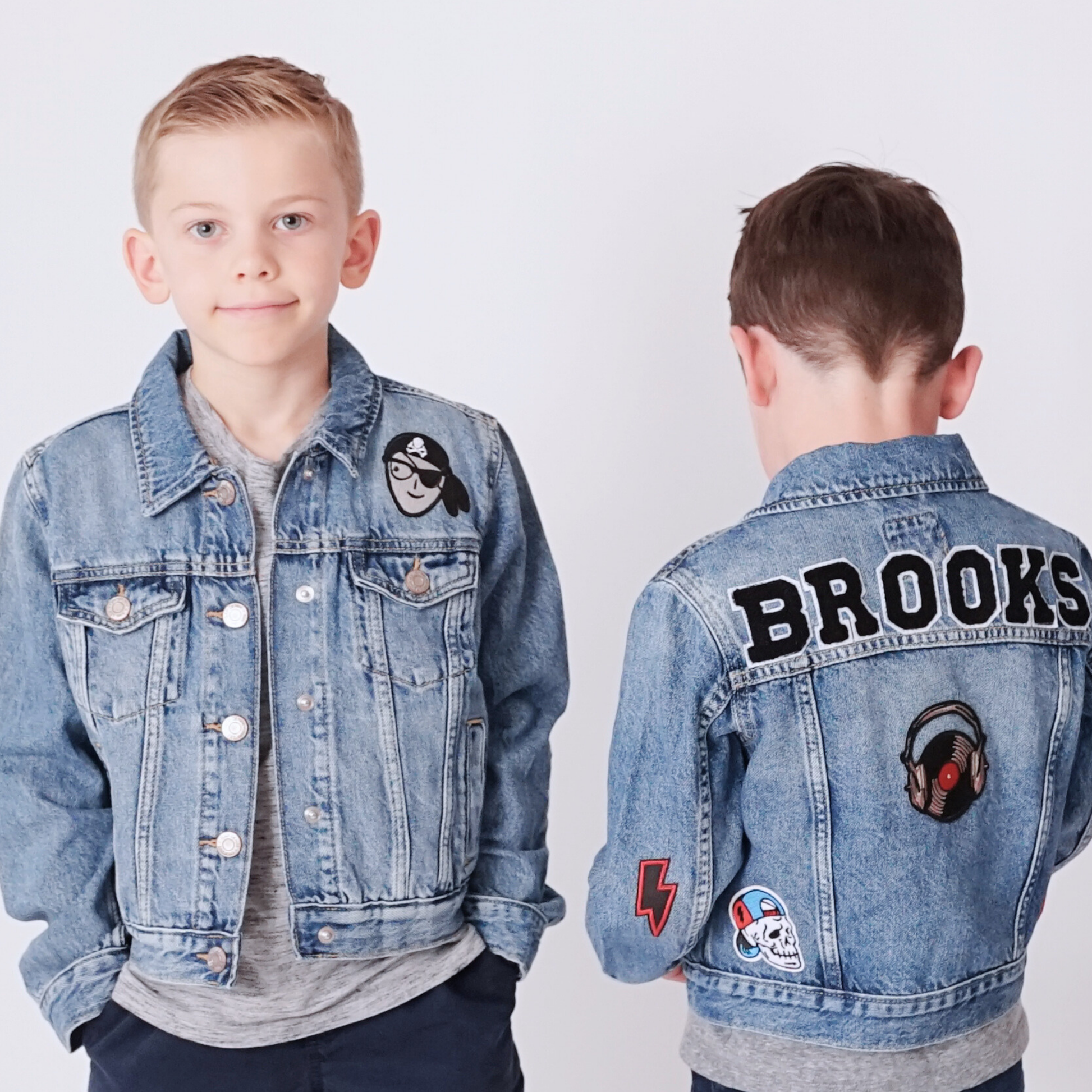 Two children wearing denim jackets with patches, one showing 'Brooks' on the back.