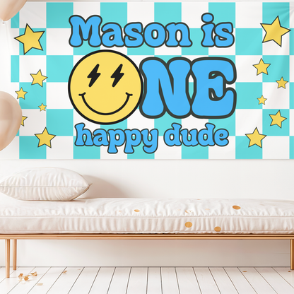 Wall decoration with 'Mason is ONE happy dude' text and smiley face on a checkered background.