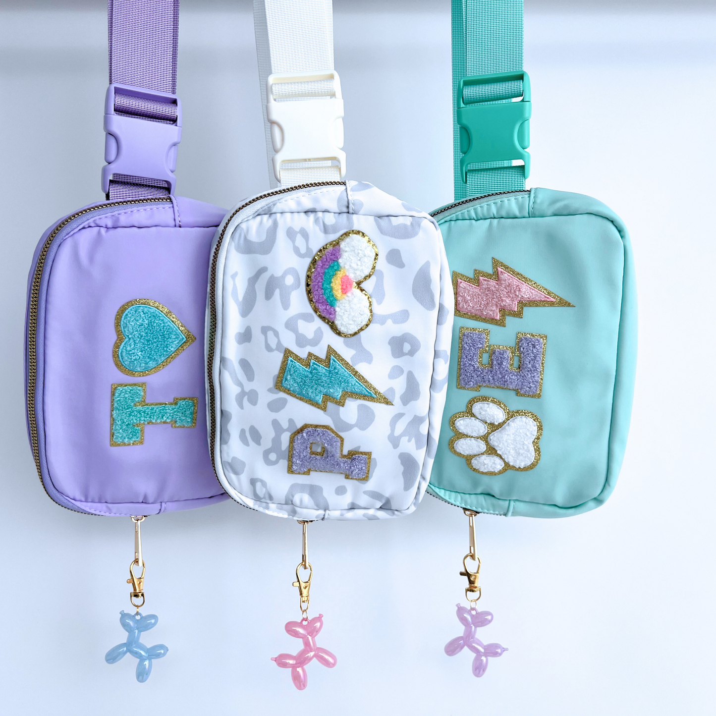 Three colorful pouches with decorative elements on a light blue background