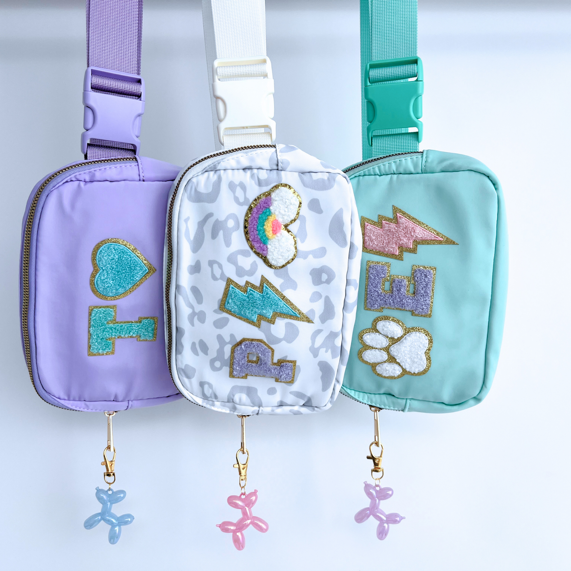Three colorful pouches with decorative elements on a light blue background