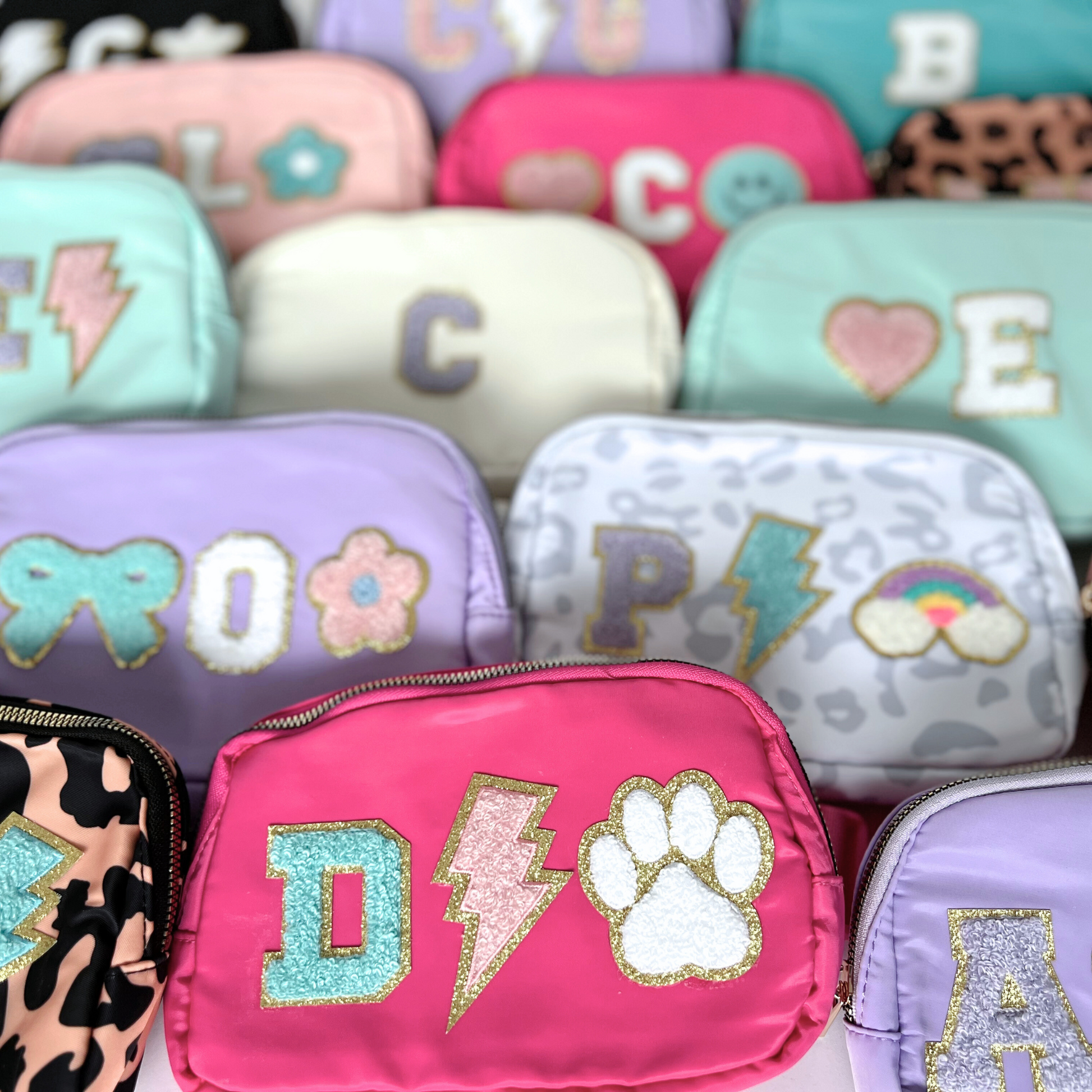 Group of fanny packs with initials in various colors