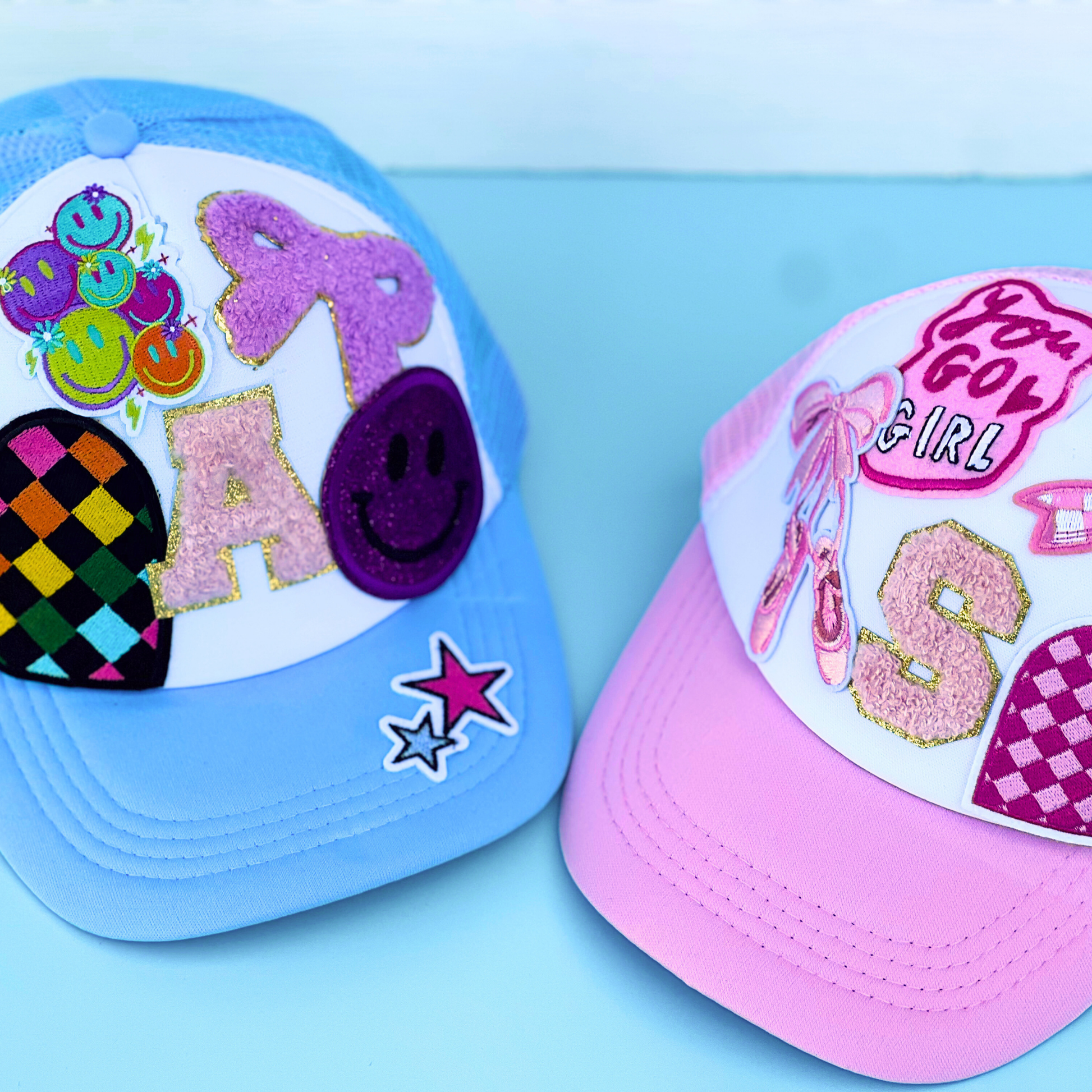 Two colorful children's caps with decorative elements on a light blue background