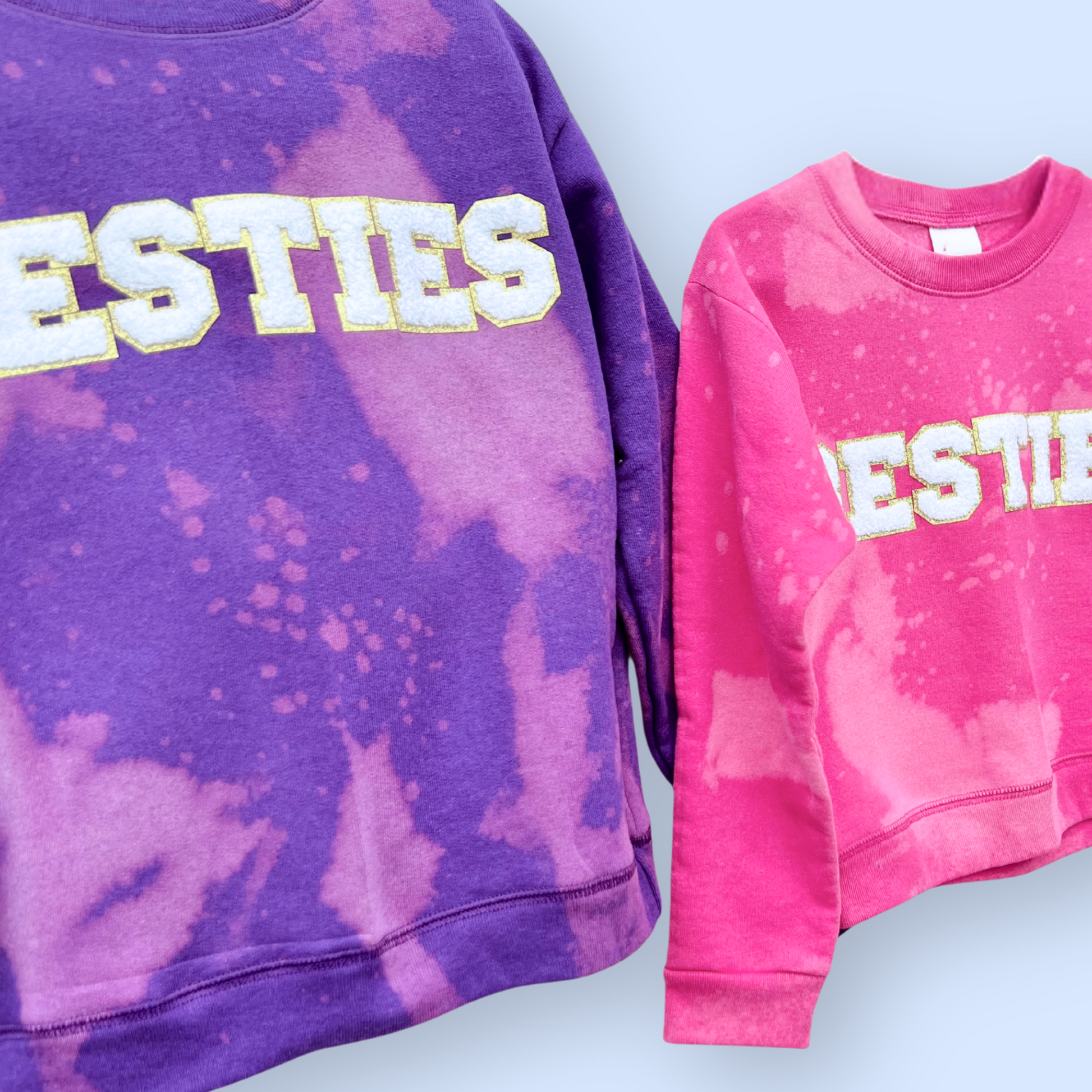 Two tie-dye sweatshirts, one purple and one pink, with 'ESTIES' printed on them.