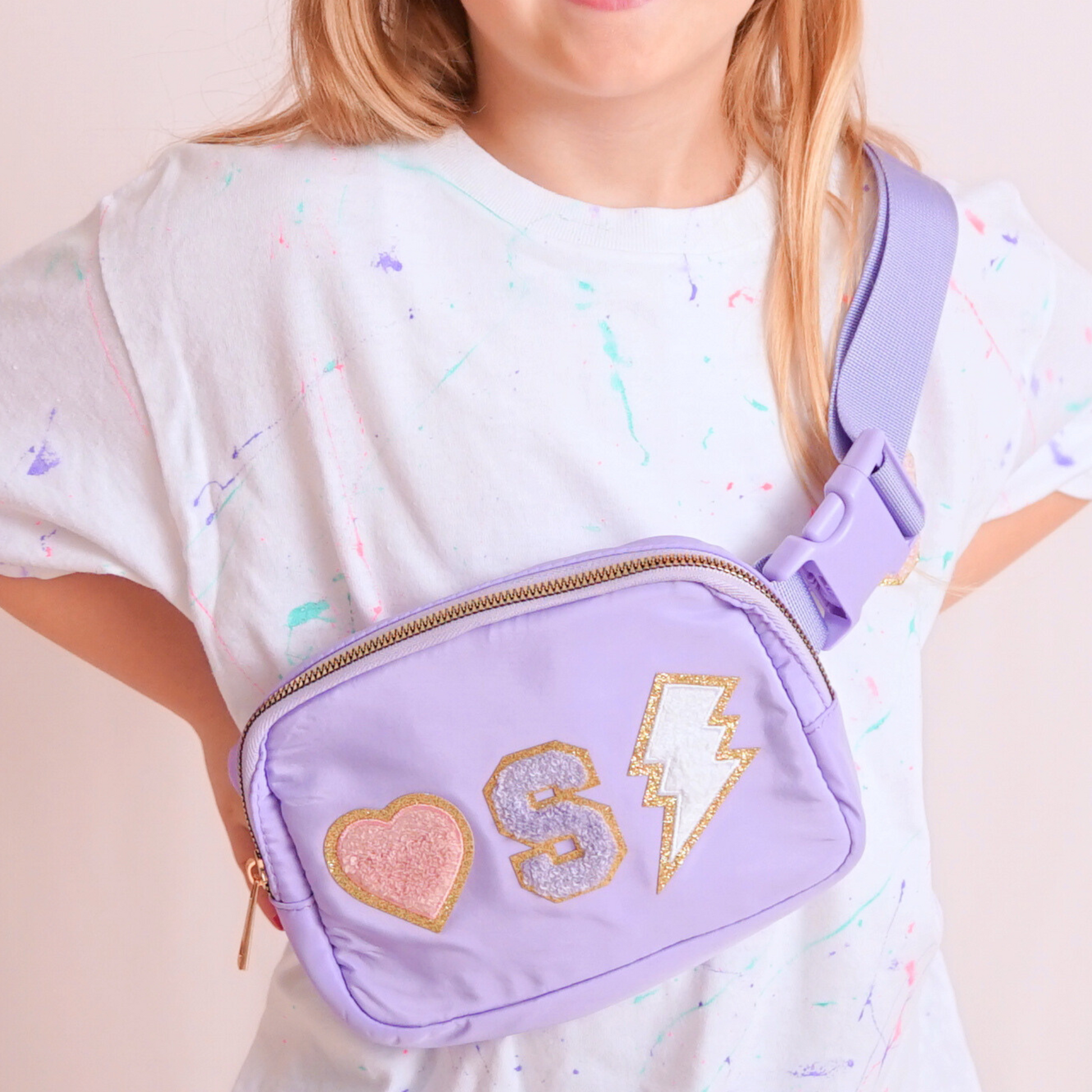 Girl modeling purple fanny pack with an S and chenille patches