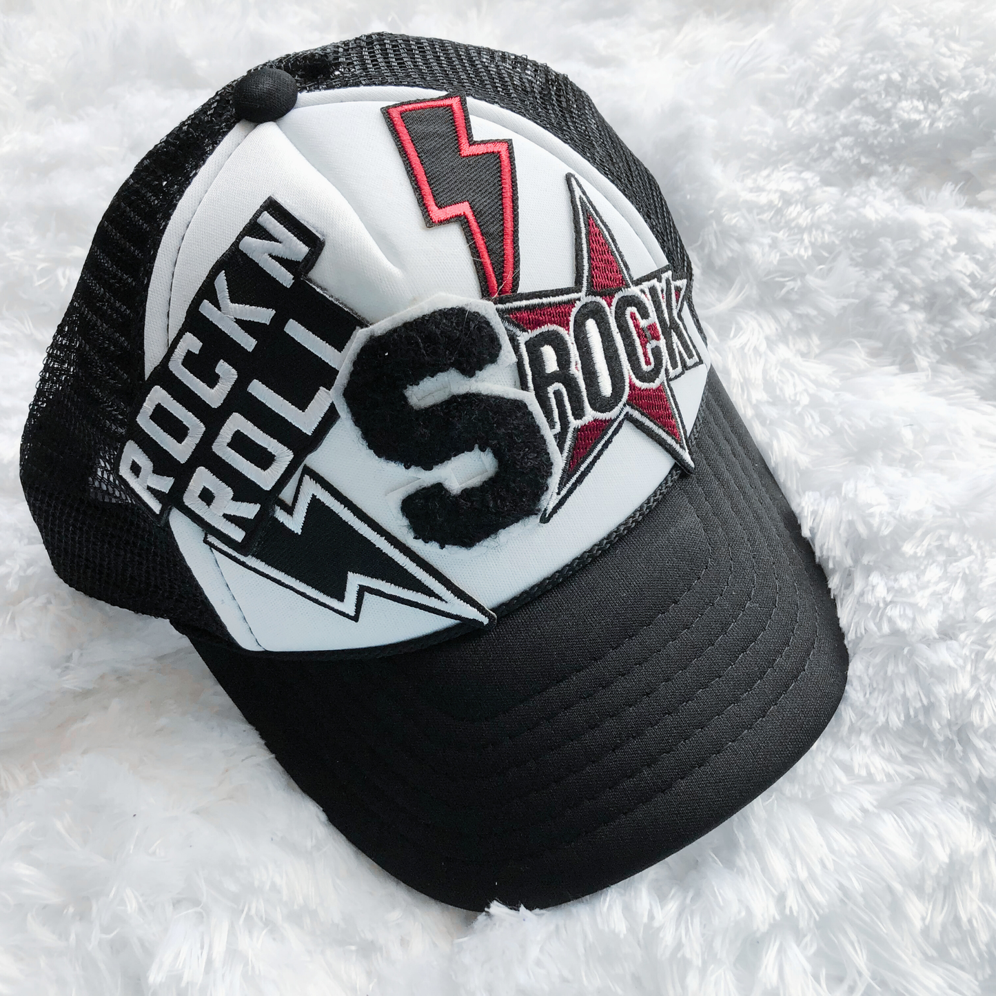 Black and white cap with 'Rock n Roll' and lightning bolt design on a white background