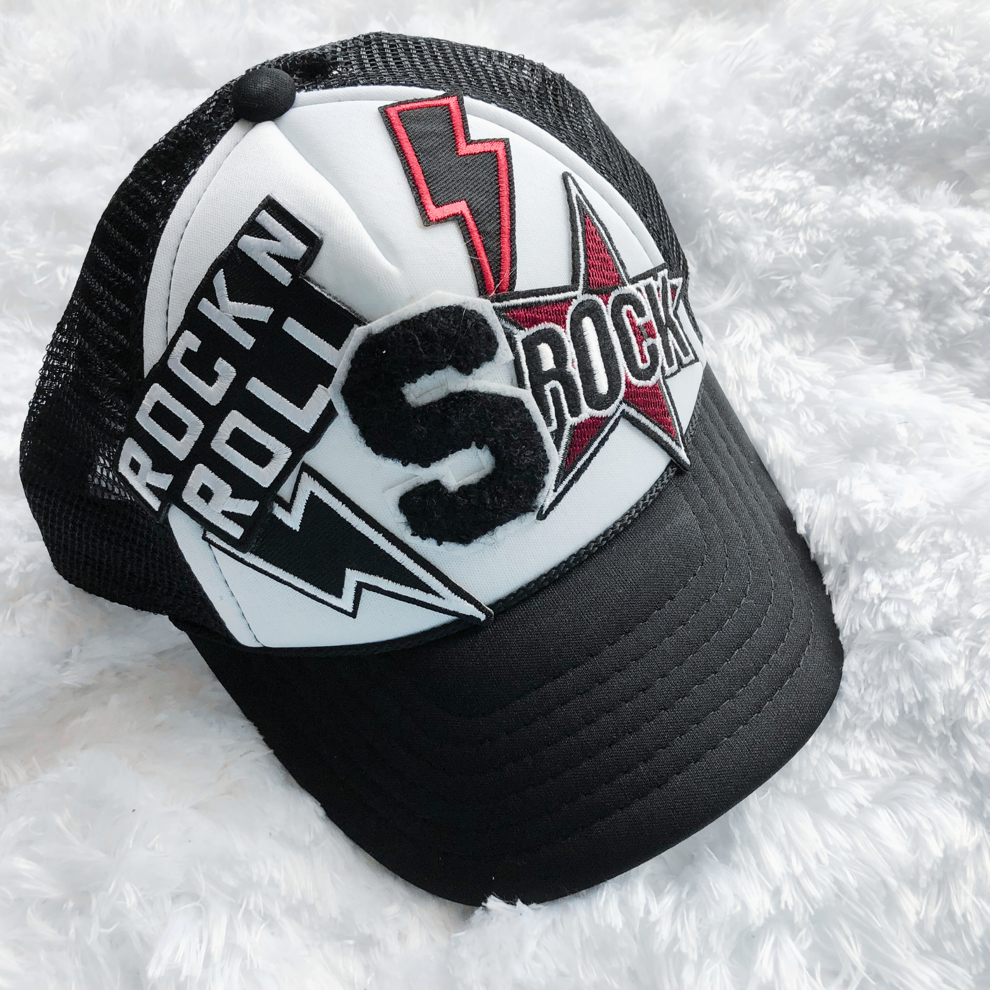 Black and white cap with 'Rock n Roll' and lightning bolt design on a white background