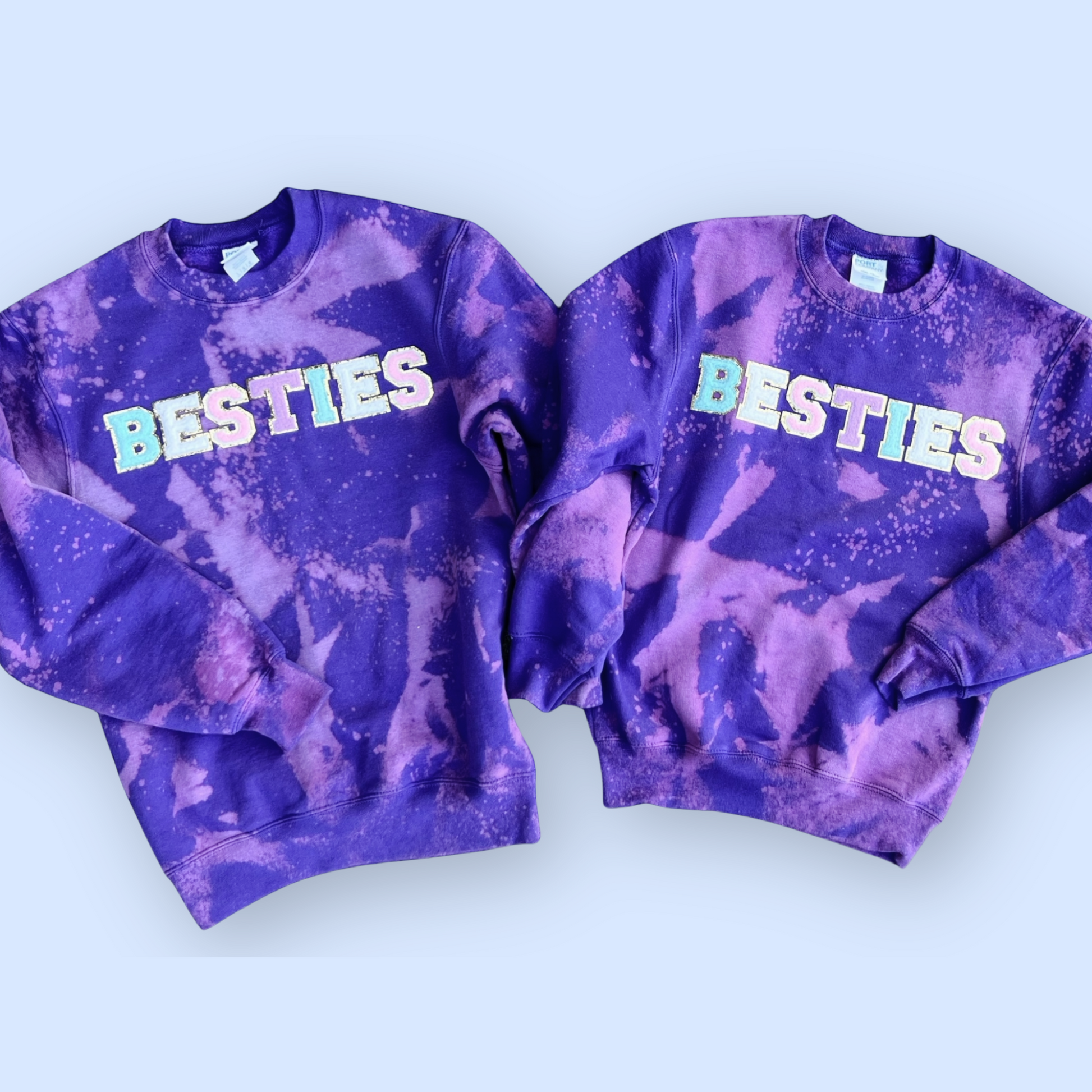 Two purple tie-dye sweatshirts with 'BESTIES' text on a light blue background