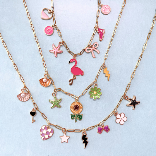 Multiple gold necklaces with various colorful charms on a light blue background