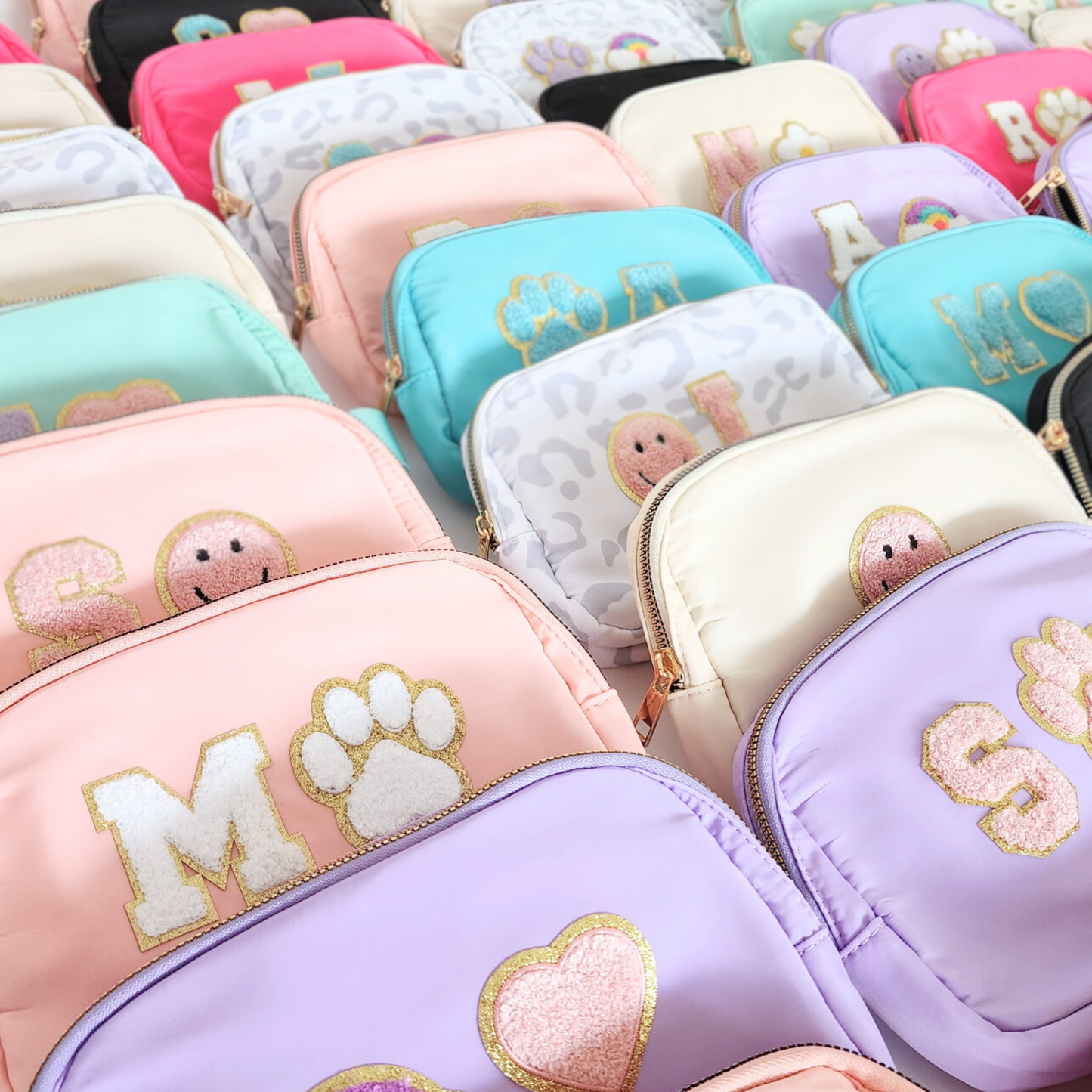 Toddler fanny pack collection in rows, colorful chenille patches visible