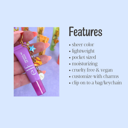 Purple lip balm with charms held by a hand on a light purple background, featuring product features.