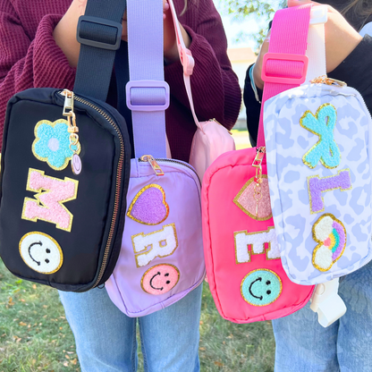Two girls holding fanny packs, showing size comparison