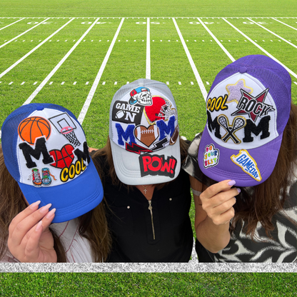 Three hats with various designs held up against a football field background
