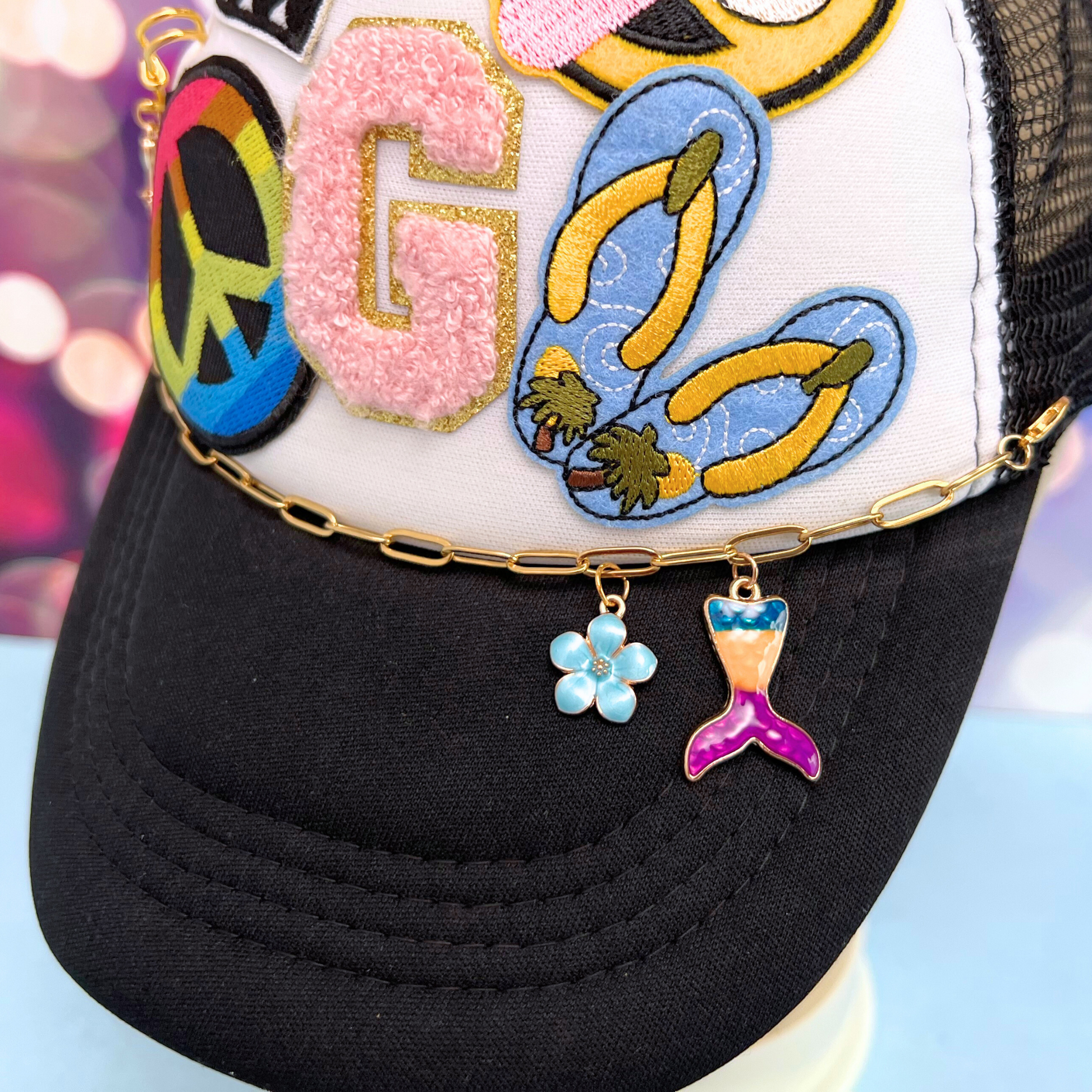Black cap with colorful patches and charms on a blurred background