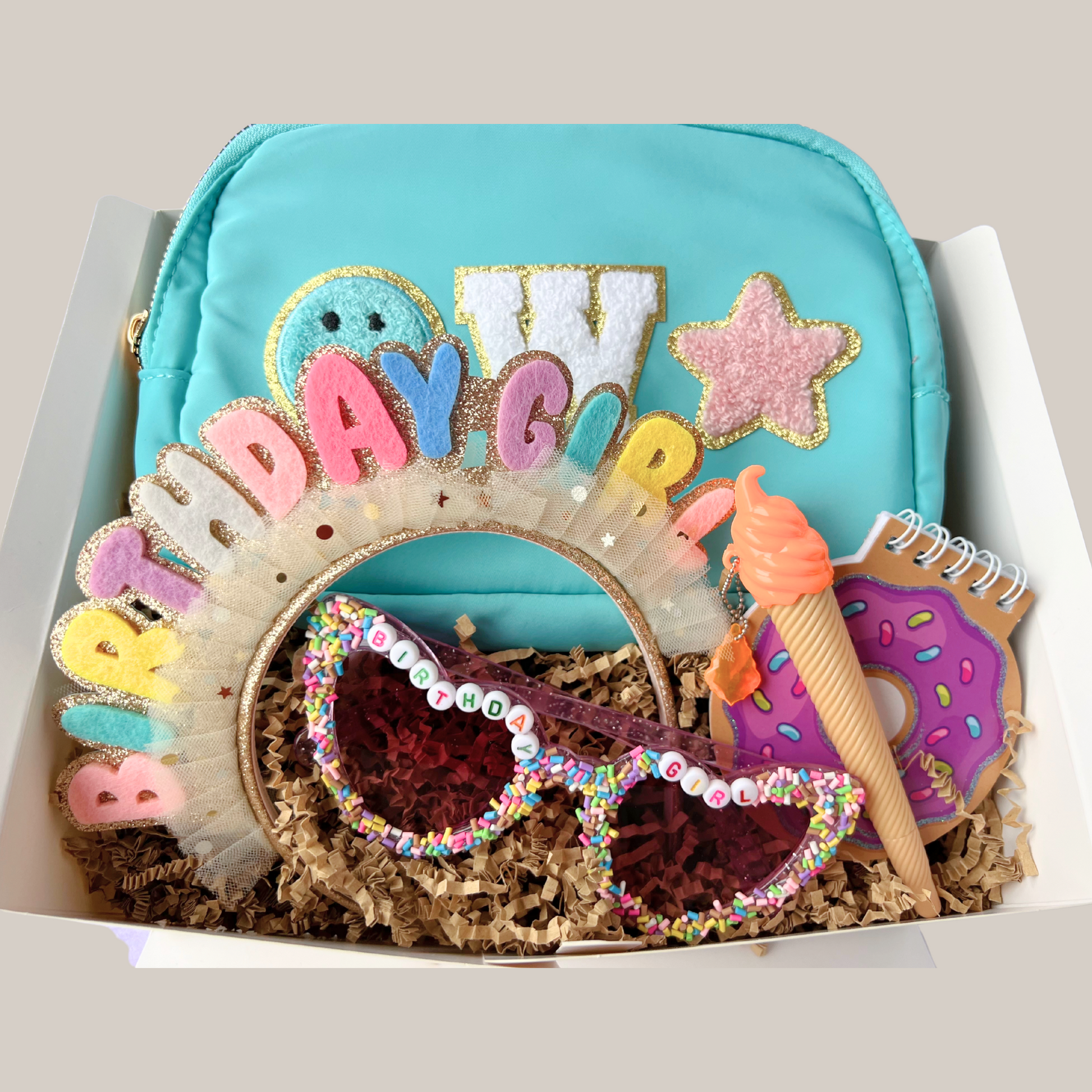 Turquoise box set – “Birthday Girl” spelled across fanny pack with sunglasses and ice cream pen in a fun birthday arrangement.