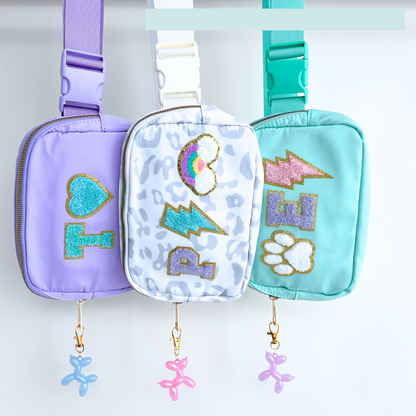 Fanny packs with charm add-ons displayed hanging
