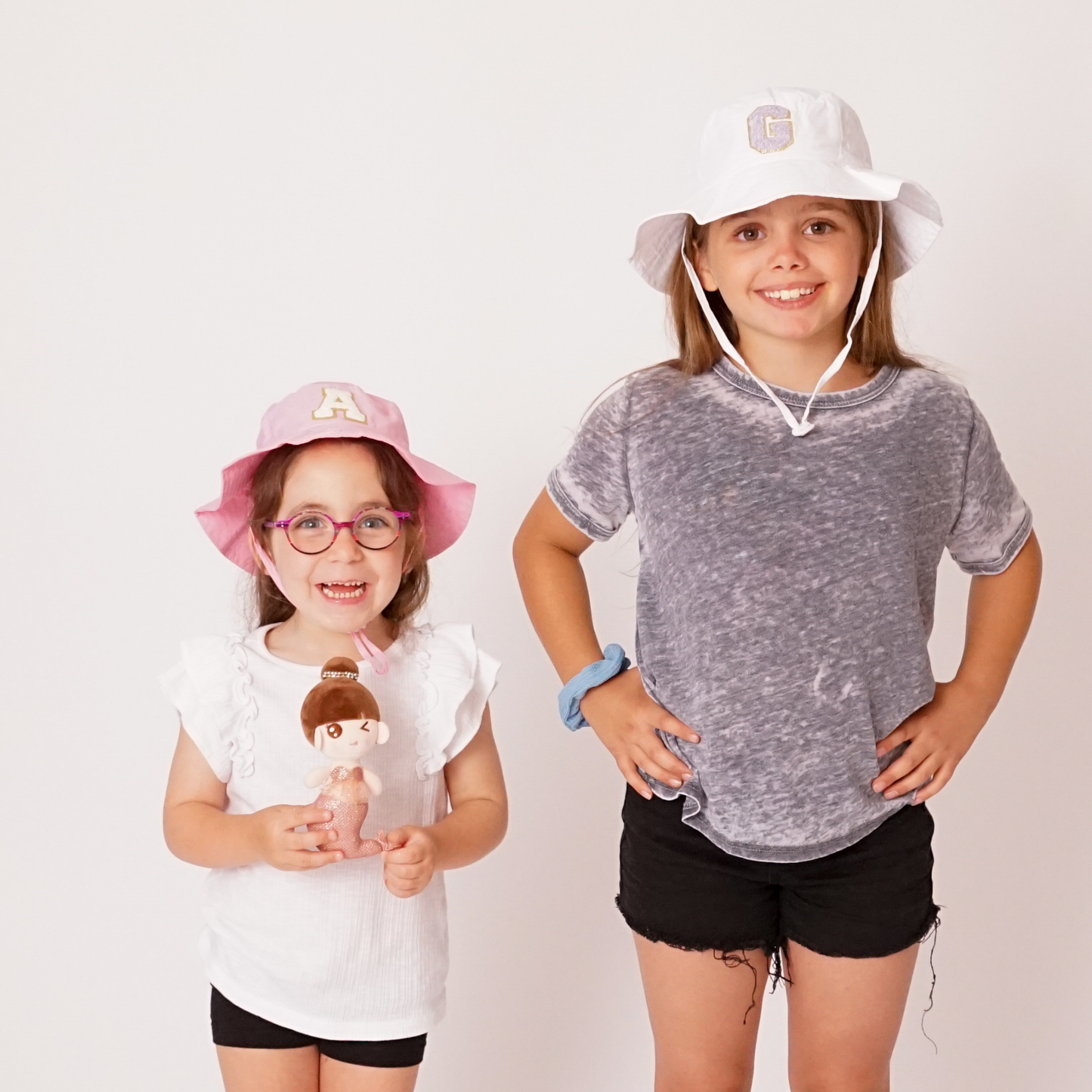 Group of children of different ages wearing sun hats in assorted colors with personalized patches