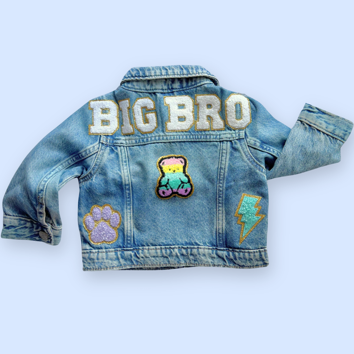 Denim jacket with 'BIG BRO' text and patches on a light blue background
