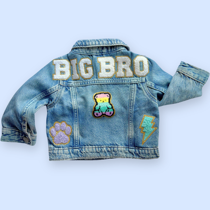 Denim jacket with 'BIG BRO' text and patches on a light blue background