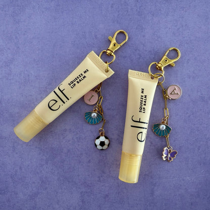 Two e.l.f. lip balm keychains with charms on a purple background