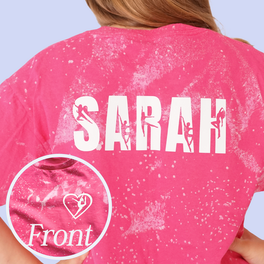 Pink t-shirt with 'SARAH' printed on the back, showing a close-up of the fabric texture. The letters have figures of a dancer inside each letter.