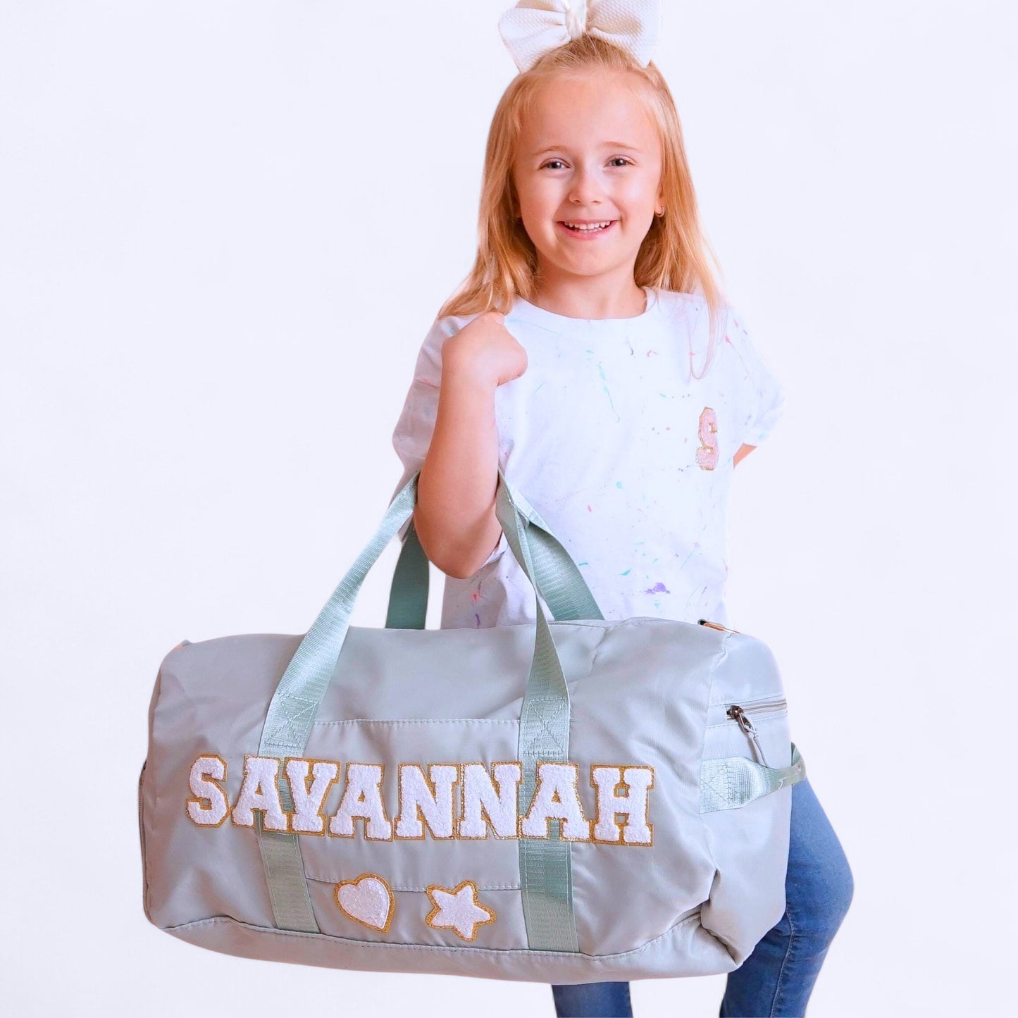Light green custom duffle bag with SAVANNAH and decorative patches.