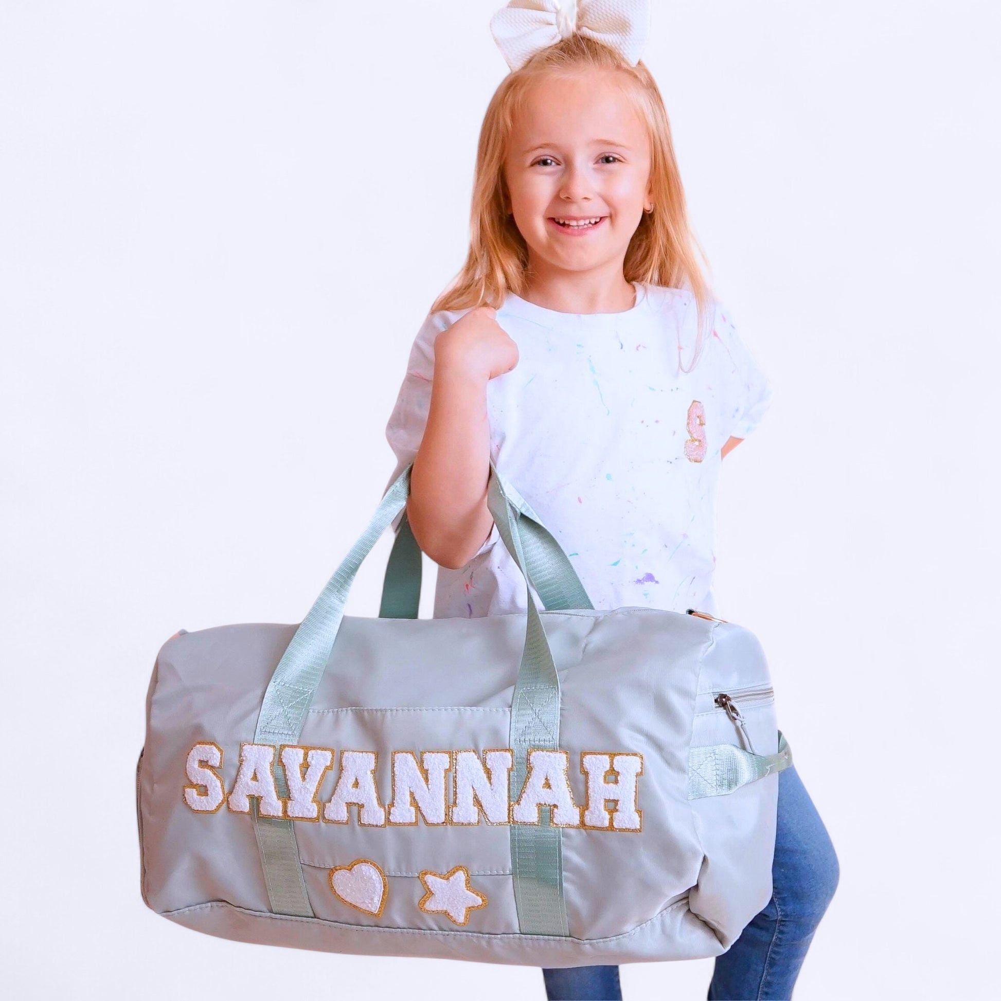 Light green custom duffle bag with SAVANNAH and decorative patches.