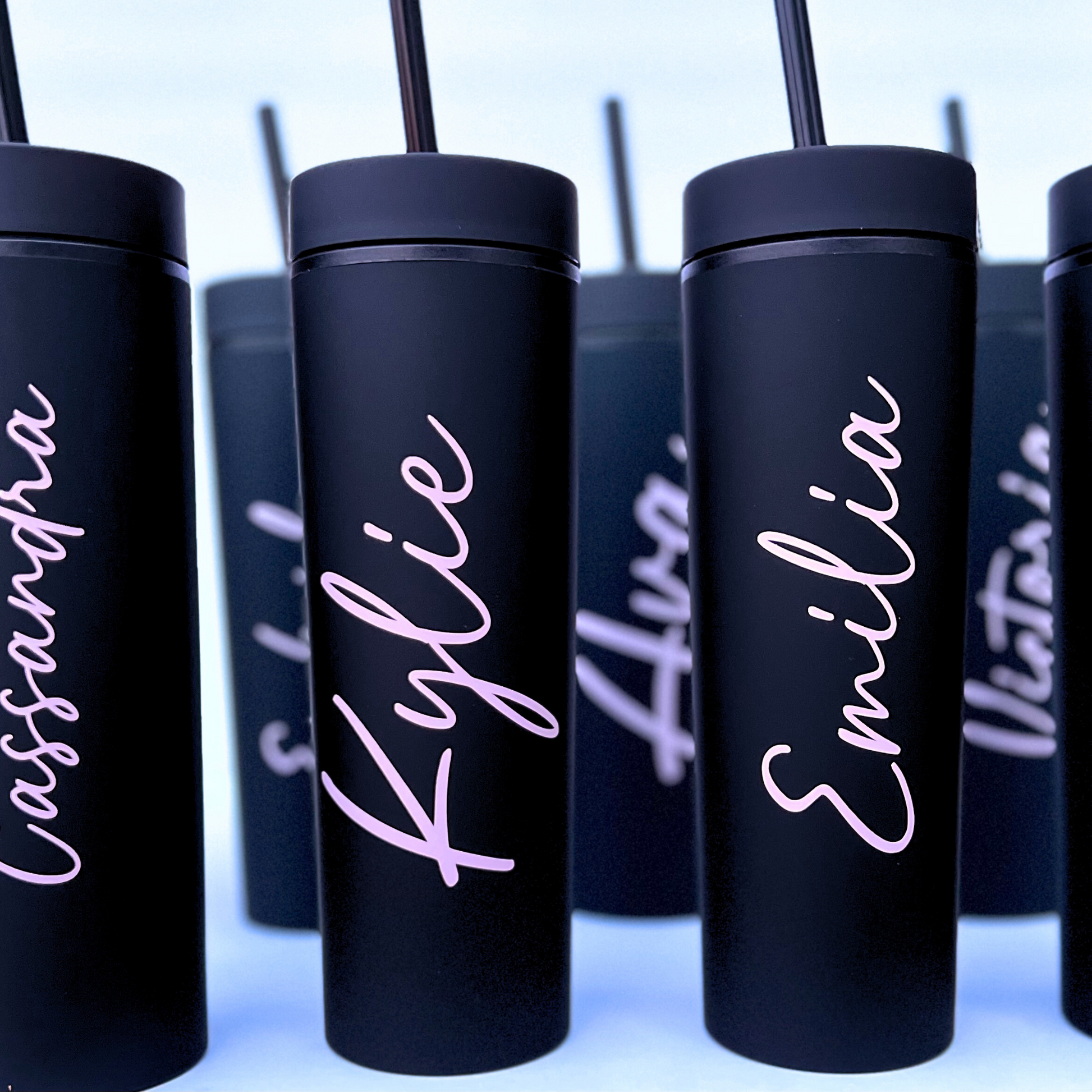  (Black tumblers):
Multiple black tumblers lined up with personalized white vinyl names like “Kylie,” “Emma,” and “Emilia.”